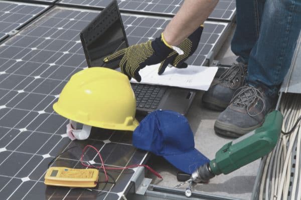 Immer häufiger in Deutschland zu sehen: ein Techniker, der eine neue Solaranlage montiert 